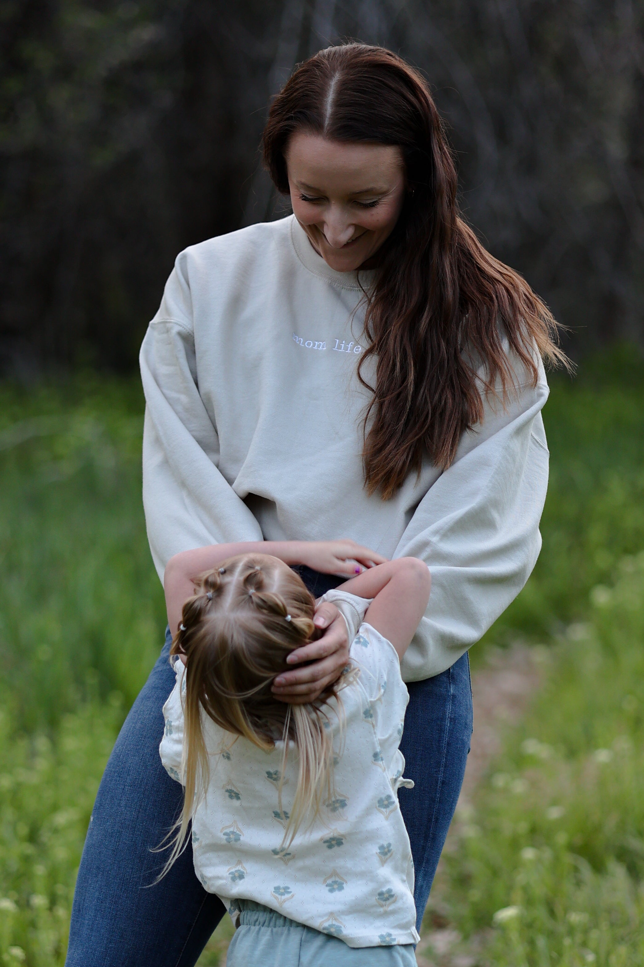 Woman and child in a grassy field in rooted (sand)
